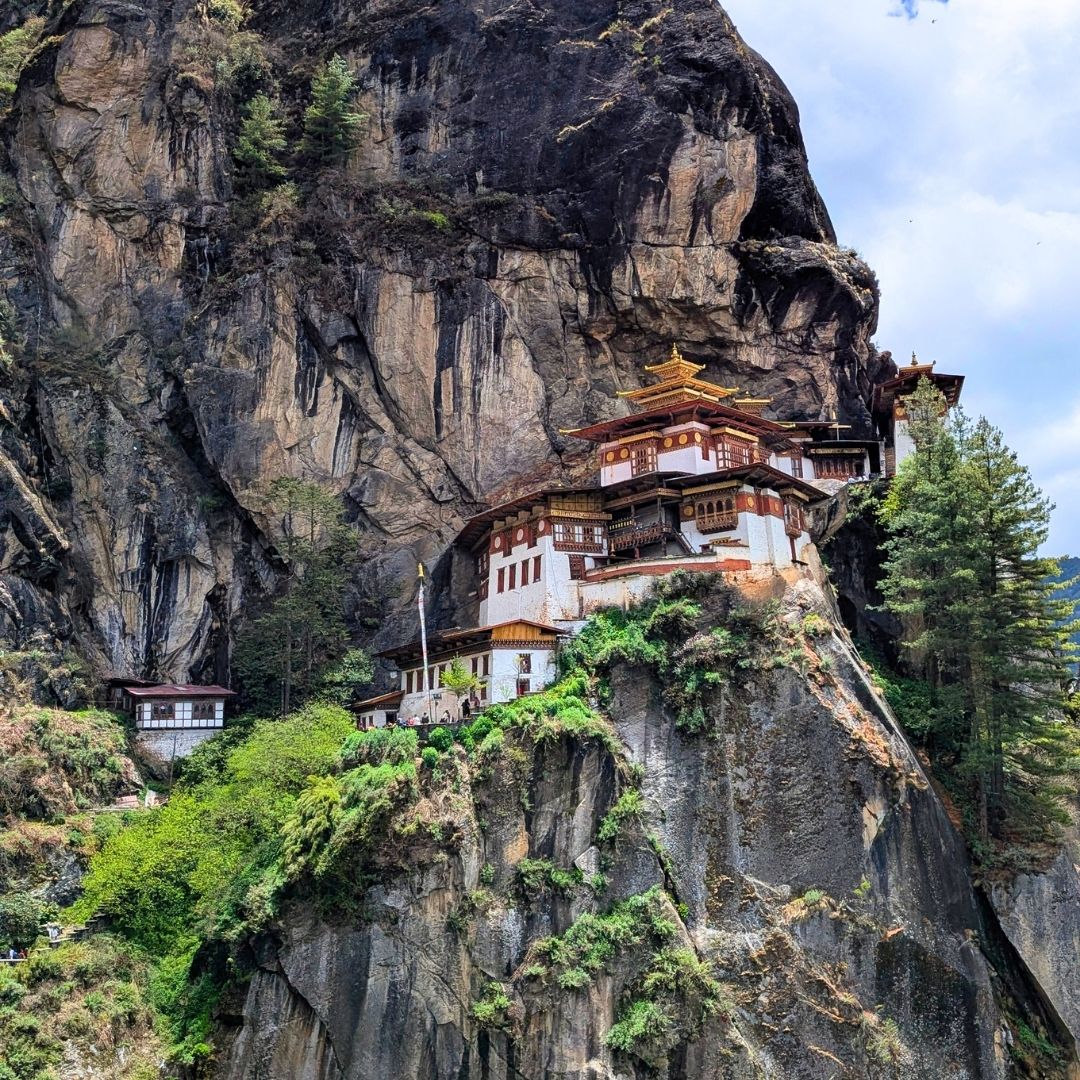 Tiger's Nest monastery built into a cliffside with lush greenery.