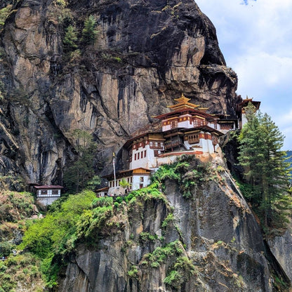 Tiger's Nest monastery built into a cliffside with lush greenery.